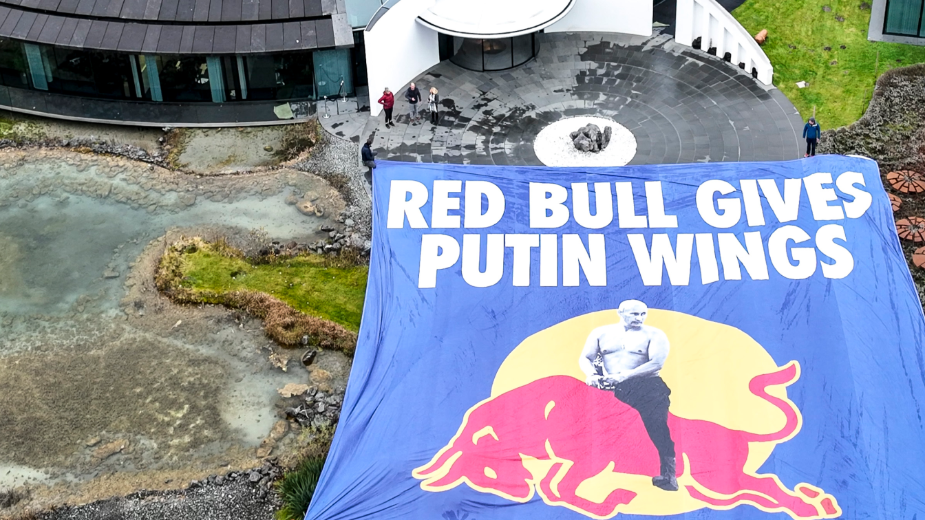 "Red Bull gives Putin Wings" steht auf einem großen Transparent, das Aktivisten vor dem Hauptquartier von Red Bull aufgebreitet haben