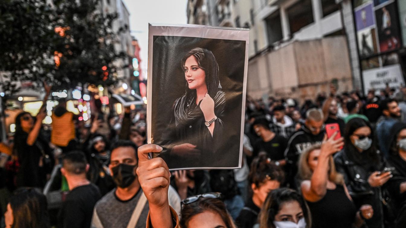 Bei Protesten im Iran hält jemand das ein Bild von Mahsa Amini in die Höhe.
