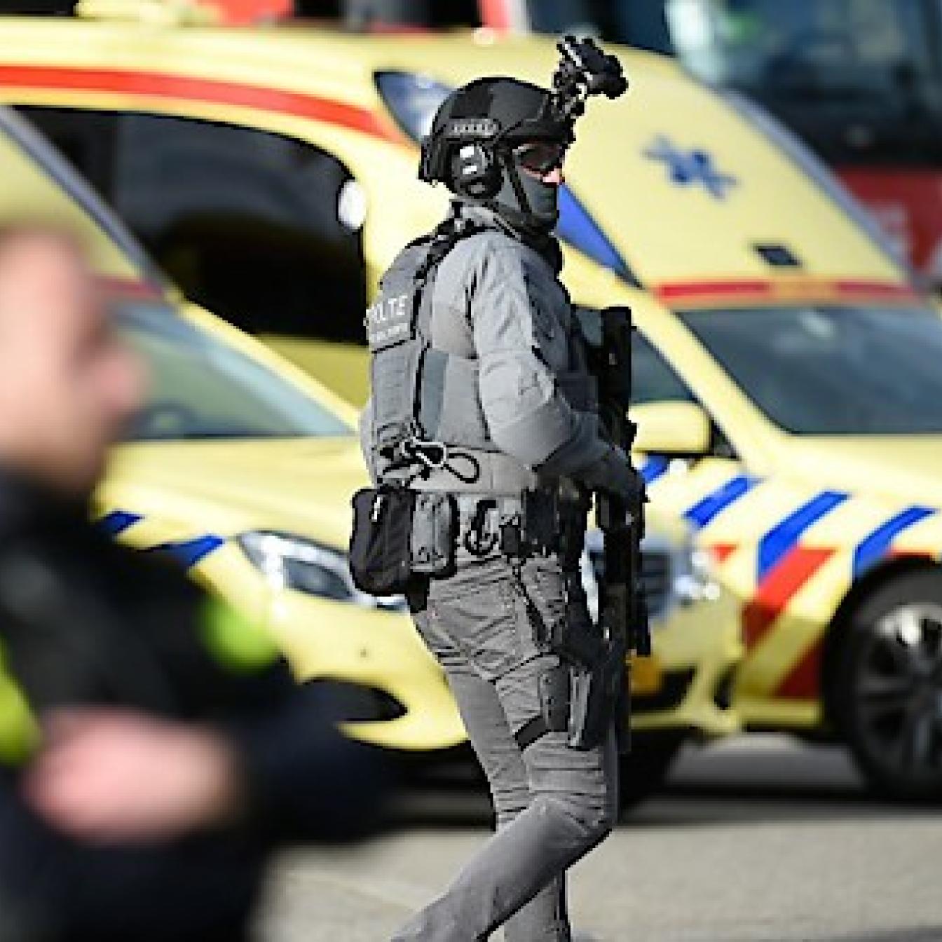 Niederländischer Polizist vor Rettungsautos.