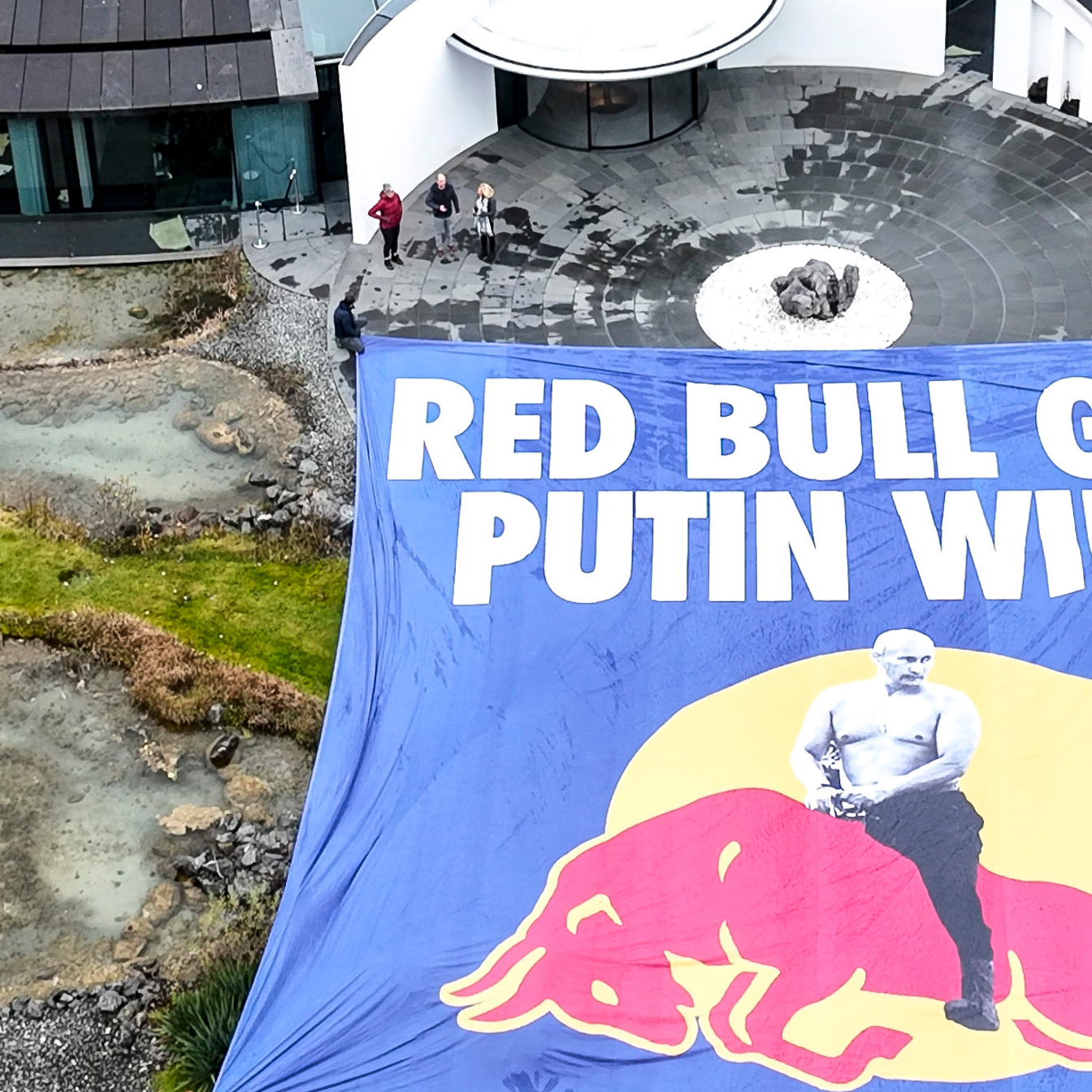 "Red Bull gives Putin Wings" steht auf einem großen Transparent, das Aktivisten vor dem Hauptquartier von Red Bull aufgebreitet haben