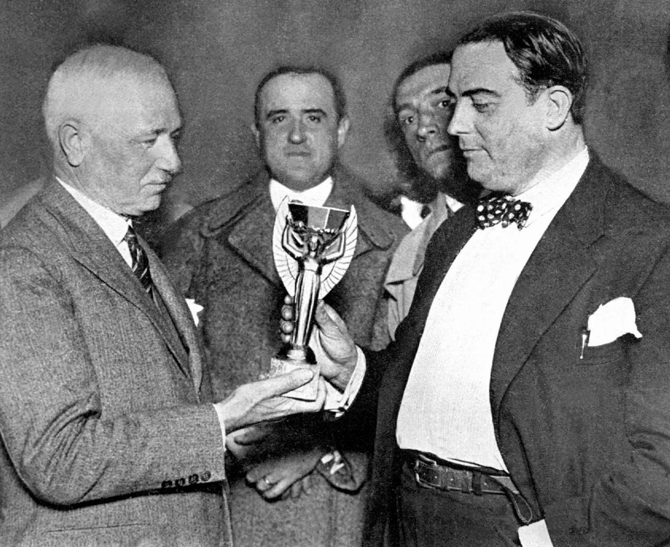 renchman Jules Rimet (L), head of the Federation Internationale de Football Association (FIFA) hands over the World Cup trophy to Dr Raul Jude, president of the Uruguayan football association 05 July 1930 in Montevideo.